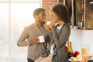 Happy morning together. Cute young african-american couple drinking coffee in cozy kitchen, panorama, copy space taking care of birth control side effects