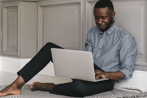 serious black male student looking at laptop listening lecture study online on computer e learning. High quality photo routine STI STD testing Nigeria